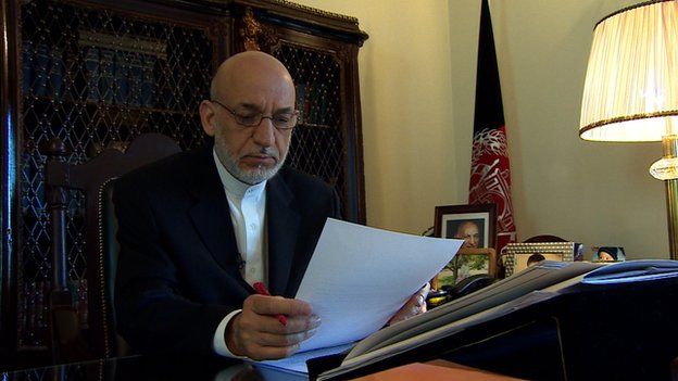 Hamid Karzai sits at his desk in June 2014