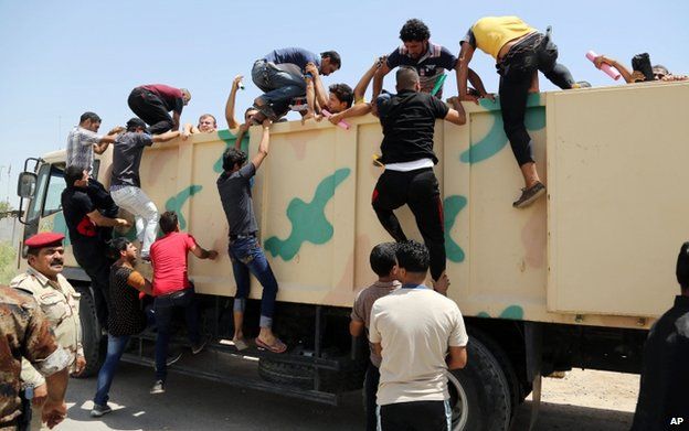 Young Iraqis board a lorry at a recruiting centre in Baghdad, 14 June