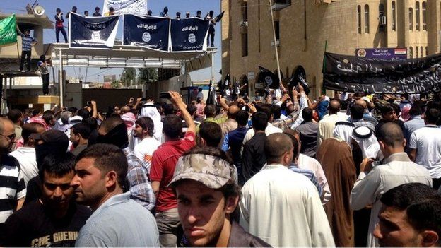 Islamic State of Iraq and the Levant supporters chant pro al-Qaida slogans in front of the provincial government headquarters in Mosul, Iraq, Monday, June 16, 2014