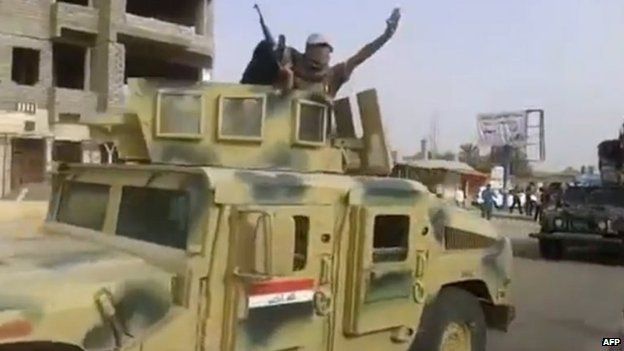 ISIS militants inside an Iraqi army Humvee armoured vehicle in Baiji (17 June 2014)