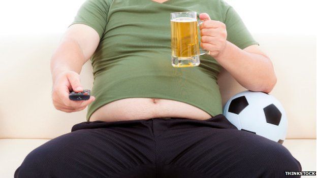 Man on sofa with remote and beer