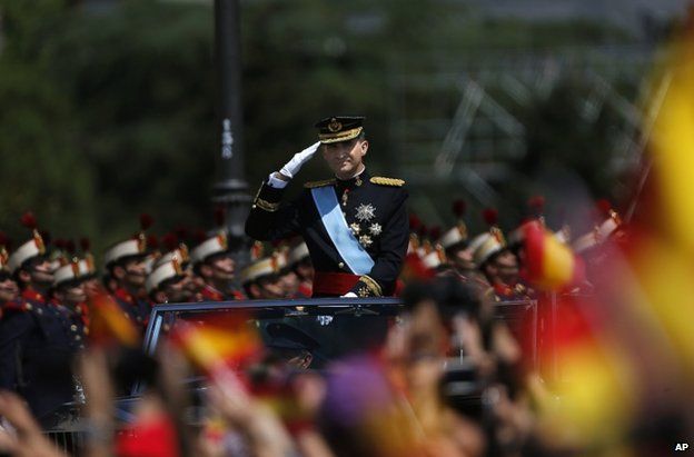 King Felipe salutes to the crowd as he rides in an open-top Rolls Royce during his arrival at the Royal Palace in Madrid, Spain, 19 June