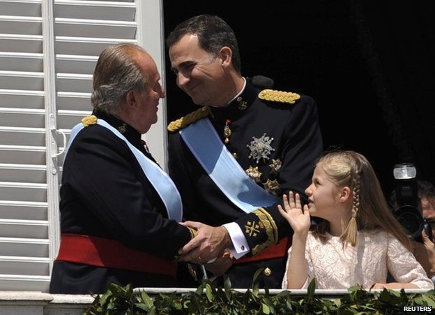 Juan Carlos (L) shakes hands with King Felipe on the balcony of the royal palace in Madrid, 19 June