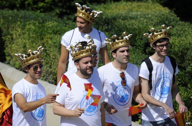Men in carnival crowns near the royal palace in Madrid, 19 June