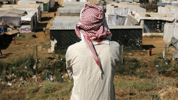 A man looking at a Syrian refugee camp in the Lebanese village of Zahle in the Bekaa valley on 17 June 2014.