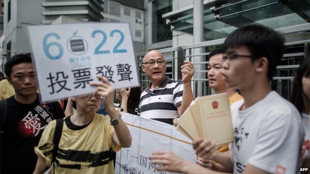 Demonstrators supporting the Occupy Central movement display placards asking residents to cast ballots
