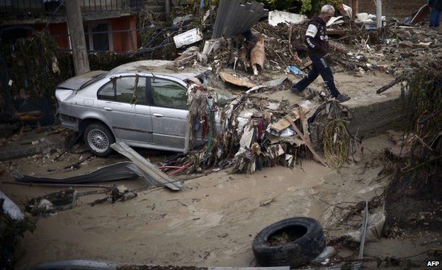 A man walks past a damaged car in a flooded street of a suburb of the Black Sea port of Varna (AFP)