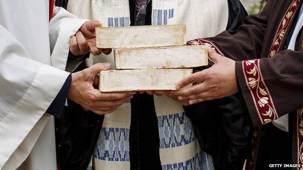 The hands of Rabbi Tovia Ben-Chorin, Father Gregor Hohberg and Imam Kadir Sanci are see as they hold symbolic bricks