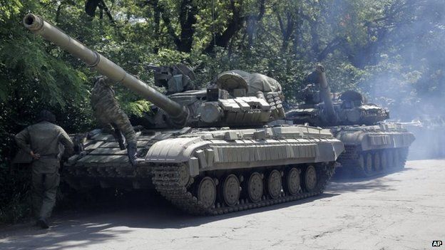 Pro-Russian troops prepare to travel in a tank on a road near the town of Yenakiyevo, Donetsk region, eastern Ukraine, Friday, June 20, 2014.