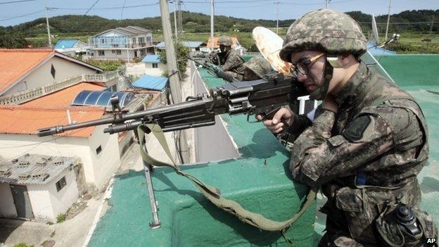Солдат целится из своего оружия в Косонге, Южная Корея, 22 июня 2014 г.