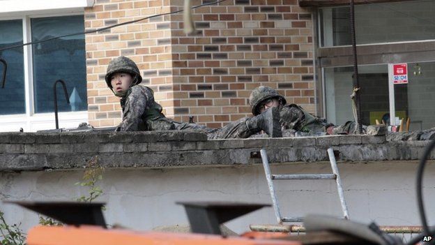 Войска занимают позицию в поисках южнокорейского солдата-отступника в Госоне, Южная Корея, 22 июня 2014 г.
