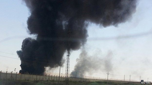 Smoke rises from a oil refinery in Baiji, north of Baghdad. 19 June 2014