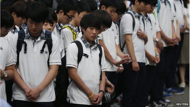 Students who survived the 16 April ferry disaster gather at the main gate as they make their way back to school in Ansan on 25 June 2014.