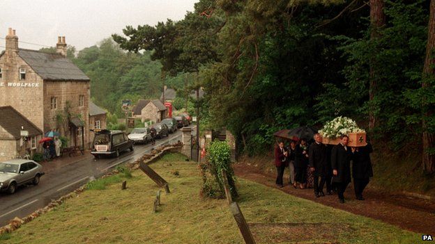 The coffin of author Laurie Lee, most famous for his novel 'Cider With Rosie' is carried to the church past his favourite pub 'The Woolpack' in Slad, Gloucestershire.