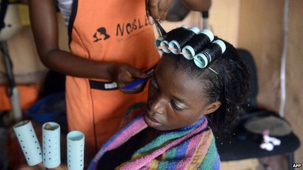 A woman having her hair done at a hair salon in Lagos Island, Lagos, Nigeria - April 2014