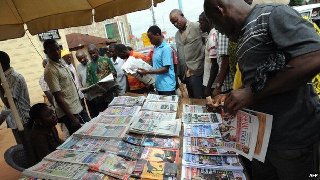 Nigerian reading newspaper headlines in Delta State - April 2011