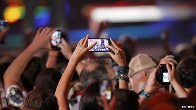 A fan uses a cell phone to record a performance during the 2014 CMT Music Awards in Nashville, Tennessee 4 June 2014