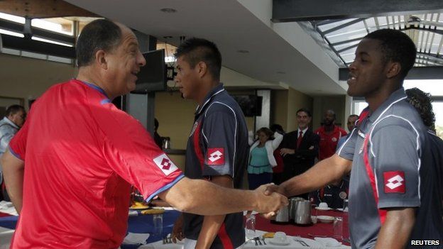 Costa Rican President Luis Guillermo Solis (left) shakes hands with football player Joel Campbell before a breakfast with the nation team on 30 May, 2014