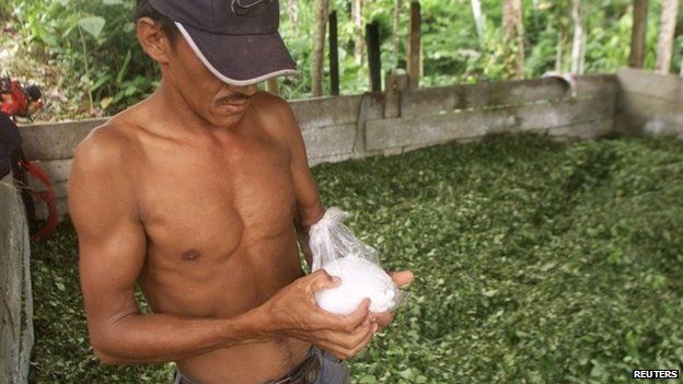 A Colombian peasant holds a bag of coca paste at a makeshift drug lab in Putumayo on 30 January, 2003