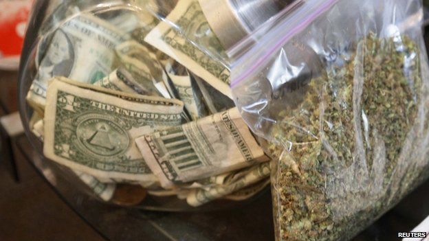 File photo: A bag of marijuana next to a money jar, Colorado, 31 December 2013
