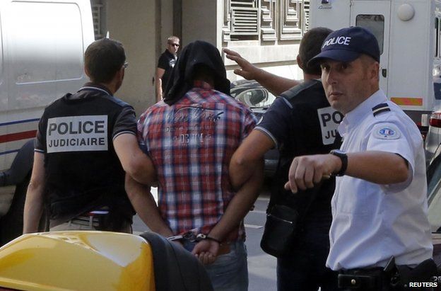 A suspect in the shooting arrives in police custody at a courthouse in Marseille, France, 27 June