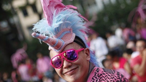 A participant dressed in pink enjoys a picnic before taking part in the forming of a giant pink dot at the Speakers" Corner in Hong Lim Park in Singapore on 28 June 2014.