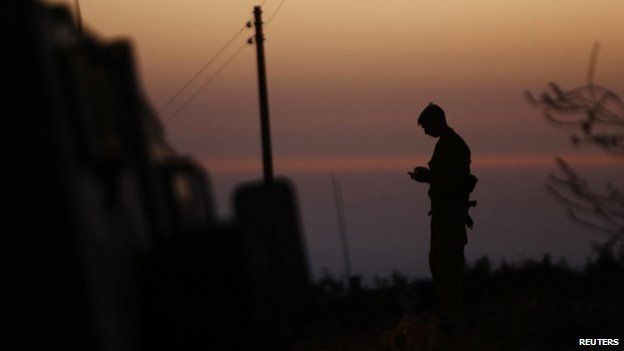 Israeli soldier stands guard near Hebron, West Bank, on 30 June 2014