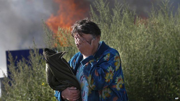 Woman cries after shelling set light to her house in Sloviansk, east Ukraine. 30 June 2014