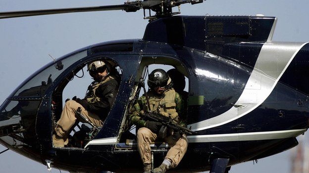 Blackwater employees in a helicopter over Iraq in February 2005