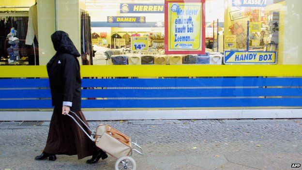 A Muslim woman passes a shop on 10 October 2001 in Berlin's heavily-Muslim Neukoelln district.