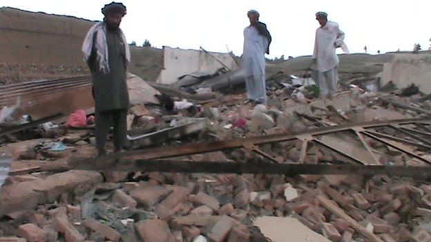Local villagers look at destruction