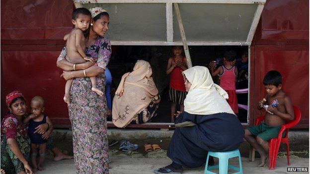 Rohingya women and their children wait to receive treatment at a makeshift clinic in the Thet Kae Pyin camp for internally displaced people in Sittwe, Rakhine state, 24 April 2014.