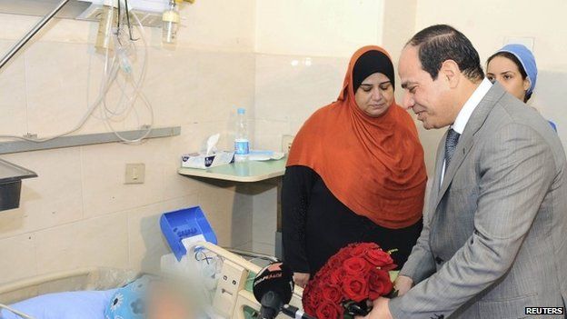 President Sisi presenting flowers to a woman who was sexually assaulted by a mob during his inauguration celebrations at a Cairo hospital on 11 June