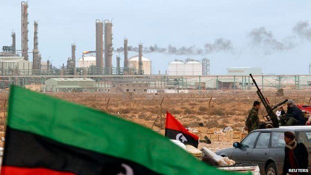 File photo: The Kingdom of Libya flag flies in front of a refinery in Ras Lanuf, 8 March 2011