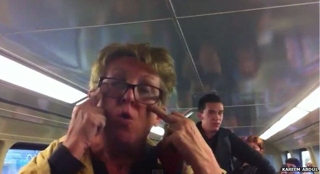 A screengrab from a YouTube video show shows a woman making a racist gesture