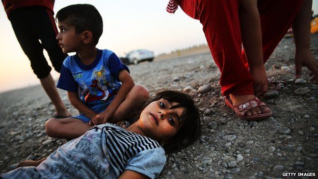 Iraqi children who fled fighting near Mosul prepare to sleep on the ground with their family in Khazair, Iraq. Photo: 3 July 2014