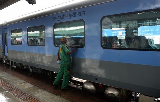 An Indian railways worker cleans a coach prior to the trial run of a high-speed train between New Delhi and Agra
