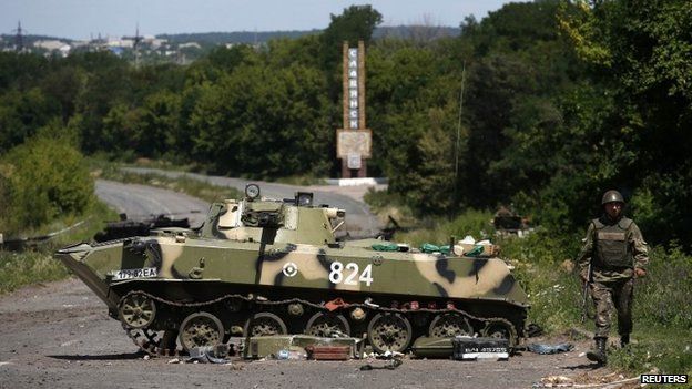 Ukrainian soldier walks near a destroyed armoured vehicle at Sloviansk in eastern Ukraine July 5