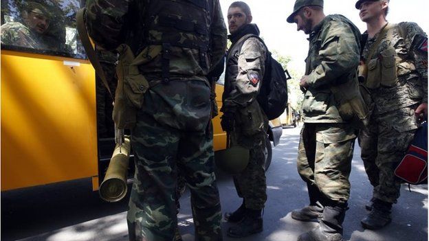 Armed pro-Russian separatists board a bus as they leave their positions in Kramatorsk in eastern Ukraine July 5