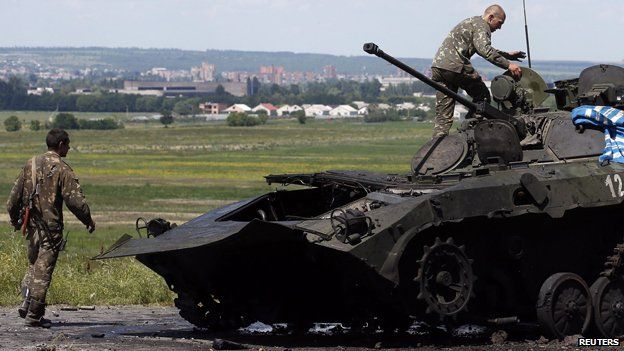 Ukrainian soldiers check a destroyed armoured vehicle at Sloviansk in eastern Ukraine July 5