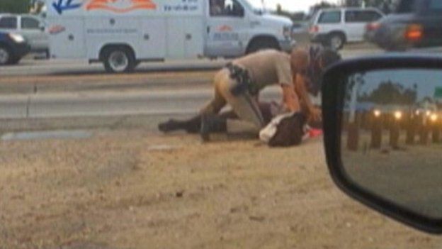 California Highway Patrol officer straddles woman on freeway
