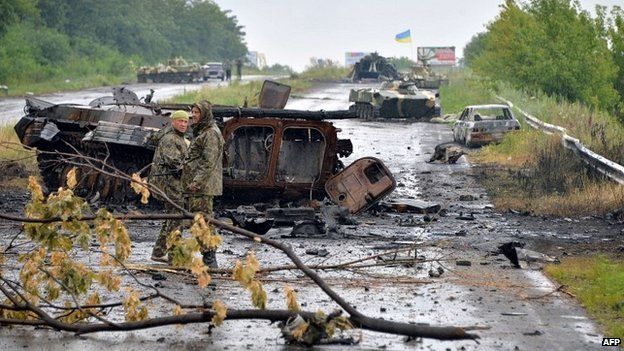 Ukrainian government soldiers stand in front of wrecked tanks and armoured personnel carriers left by pro-Russian insurgents on the outskirts of Sloviansk - 7 July 2014