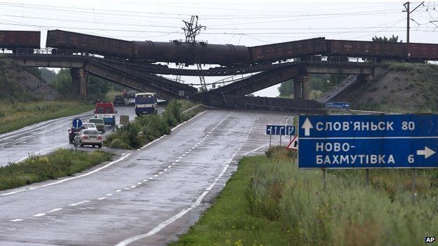 Cars queue to drive under a destroyed railroad bridge near the village of Novobakhmutivka - 7 July 2014