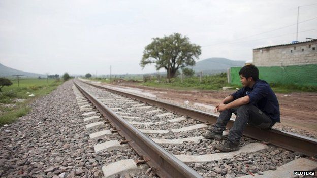 Migrant Santos Tome Hernandes, 16, from Honduras, sits on the railway tracks in Huehuetoca, outskirts of Mexico City 26 June 2014