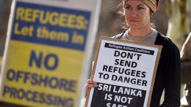 A woman holds a placard at a rally protesting the Australian government's treatment of Sri Lankan asylum seekers in Sydney on 7 July 2014.