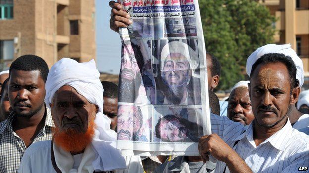 A Sudanese sympathizer holds up a local newspaper showing images of killed Al-Qaeda mastermind Osama Bin Laden as they gather to hold prayers on 3 May 2011, in Khartoum,
