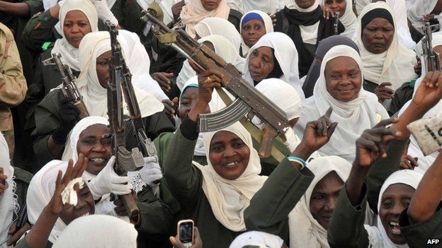 Female Sudanese soldiers cheer, holding guns in the air, during a visit from Sudan's President Omar al-Bashir to the Popular Defence Forces in Khartoum on 3 March 2012