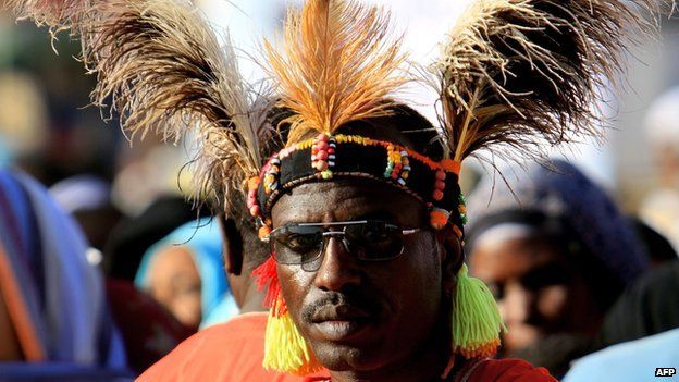 A supporter of Sudanese President Omar al-Bashir listens to his leader addressing a crowd as he inaugurates a bridge in al-Halfaya, north of Khartoum.