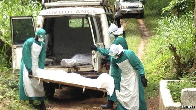 Health workers carry the body of an Ebola victim in Sierra Leone (25 June 2014)