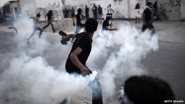 A Bahraini protestor threw a tear gas canister at riot police during clashes in Bahrain on 25 April 2014